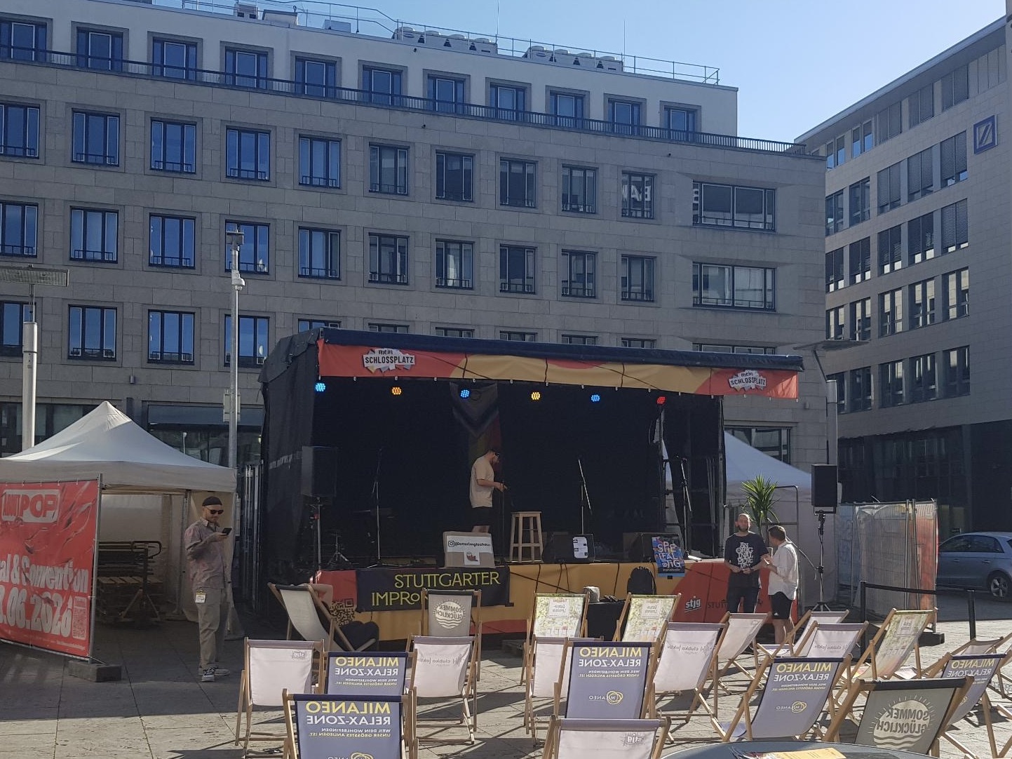 Bühne des Impro Kollektivs auf dem Kleinen Schlossplatz in Stuttgart mit Liegestühlen für das Publikum vor Beginn eines Improabends unter freiem Himmel.